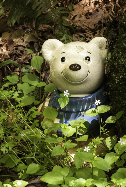 a white bear statue is in the tall green grass