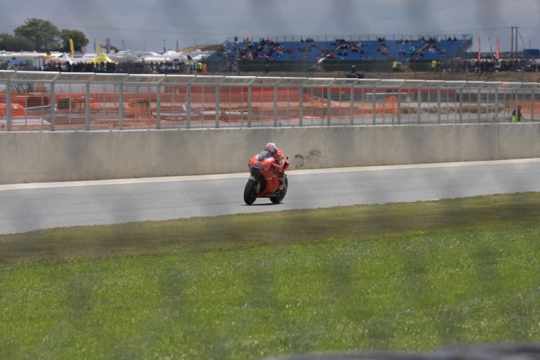 a man on a red motorcycle driving down a track