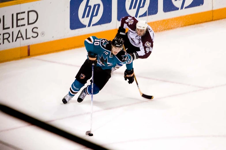 two men on ice playing hockey in front of an arena