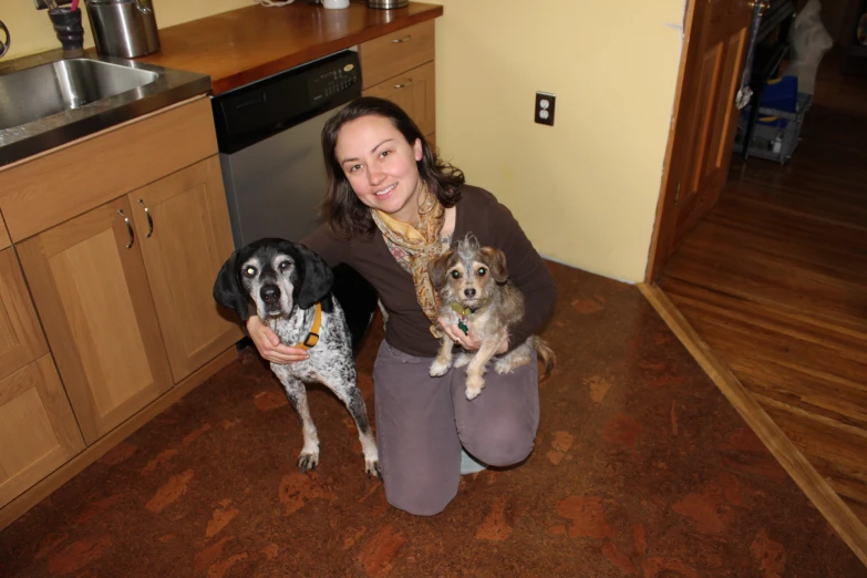 a woman sitting on the floor next to two dogs