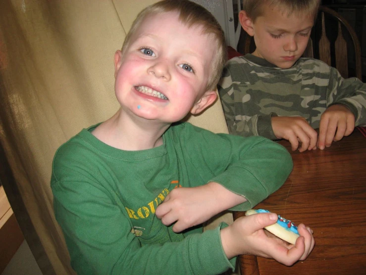 two s play with toothbrushes on the table