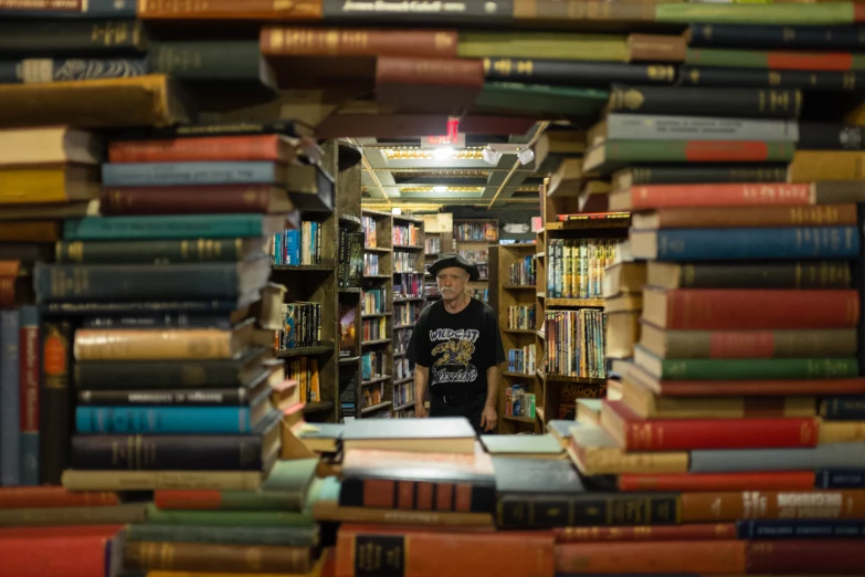 a woman standing in front of a pile of books