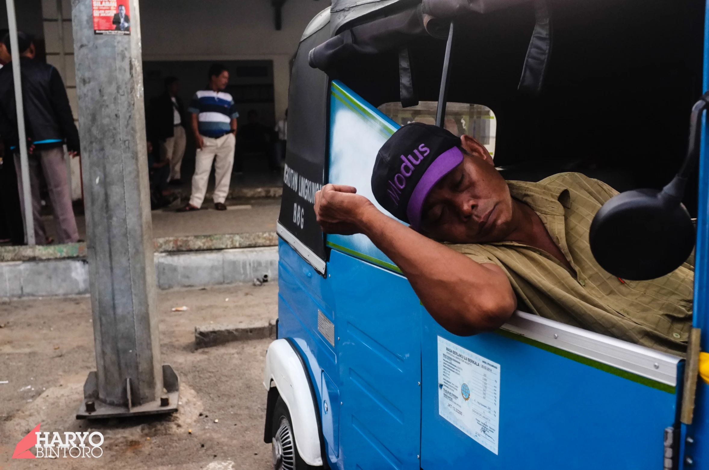 a man with a hat is sleeping in a vehicle