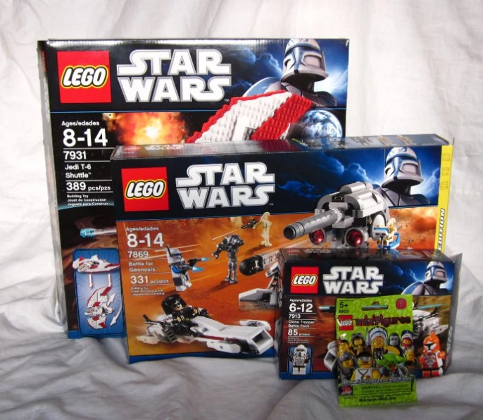 a box of lego star wars complete sets are sitting on the bed