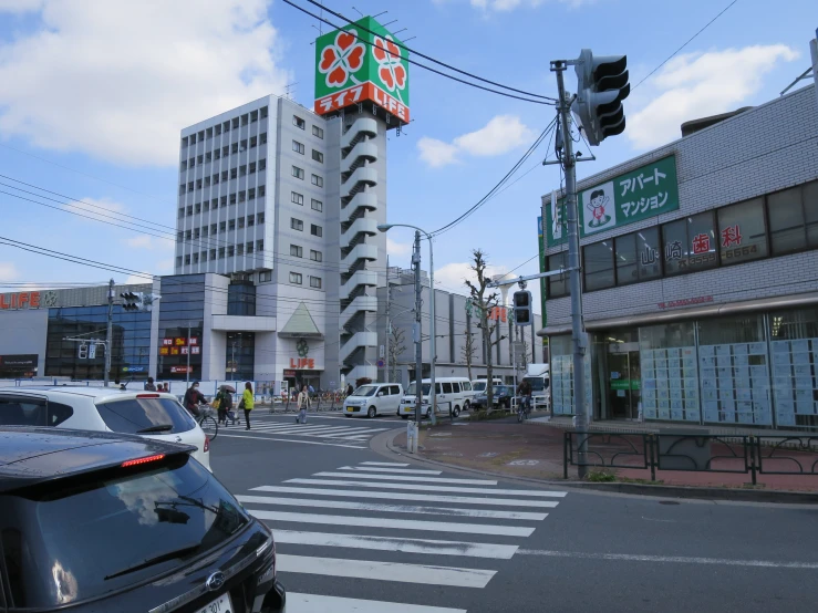 cars driving through a traffic light in front of a store