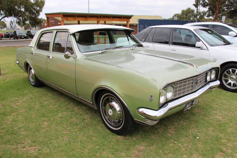 an old green car with a smaller one behind it