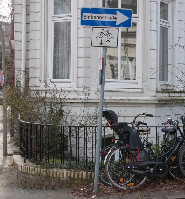 a bike and two bicycles parked by a sign