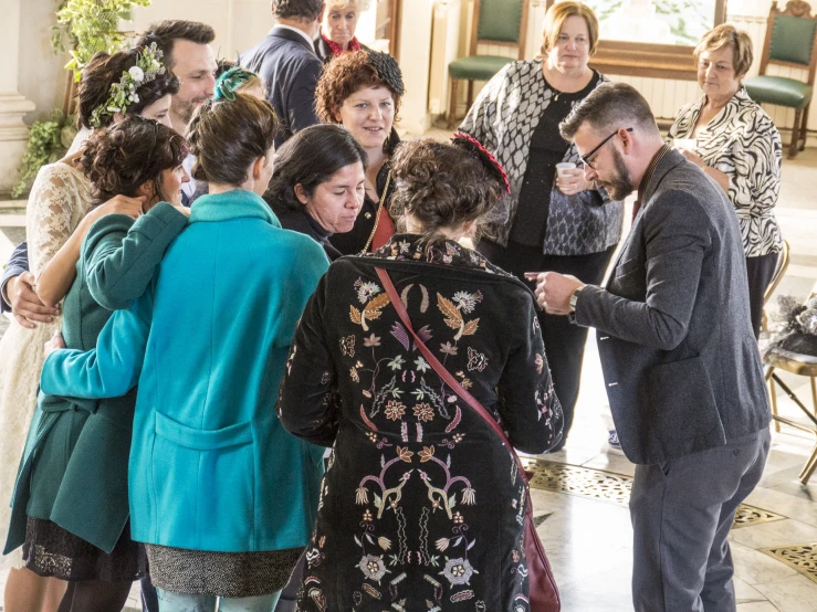 a large group of people standing together talking