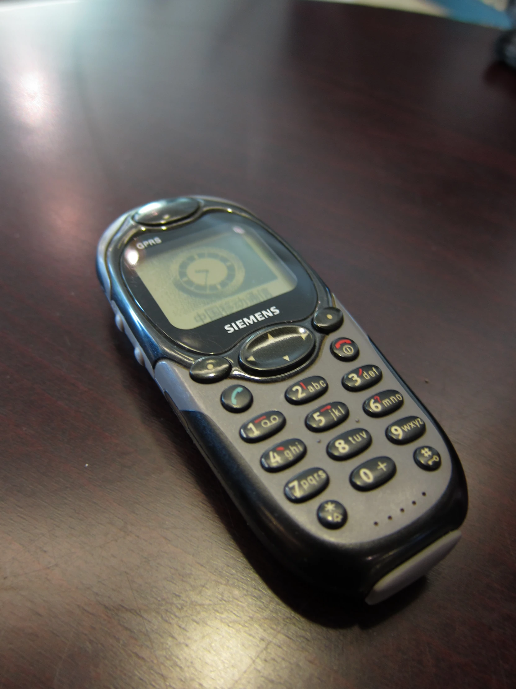 an old flip phone sitting on a table with a person's eye