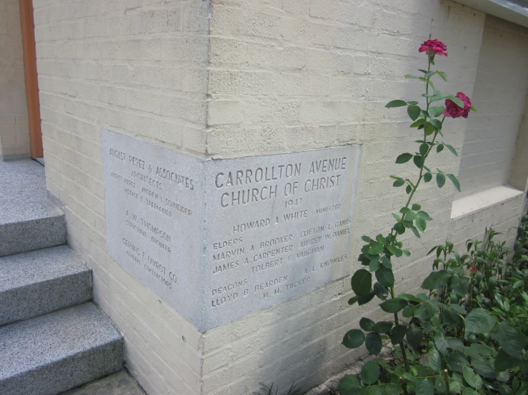 a rose is placed on a wall next to the church marker