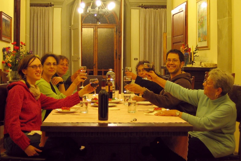 a group of people sitting around a table toasting