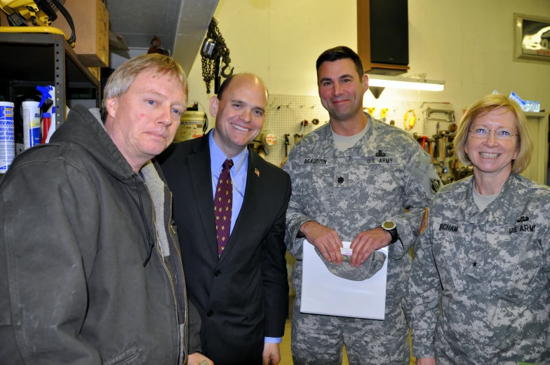 three soldiers posing with a woman and two men in a store