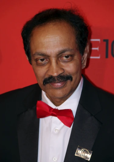 an indian man wearing a red bow tie