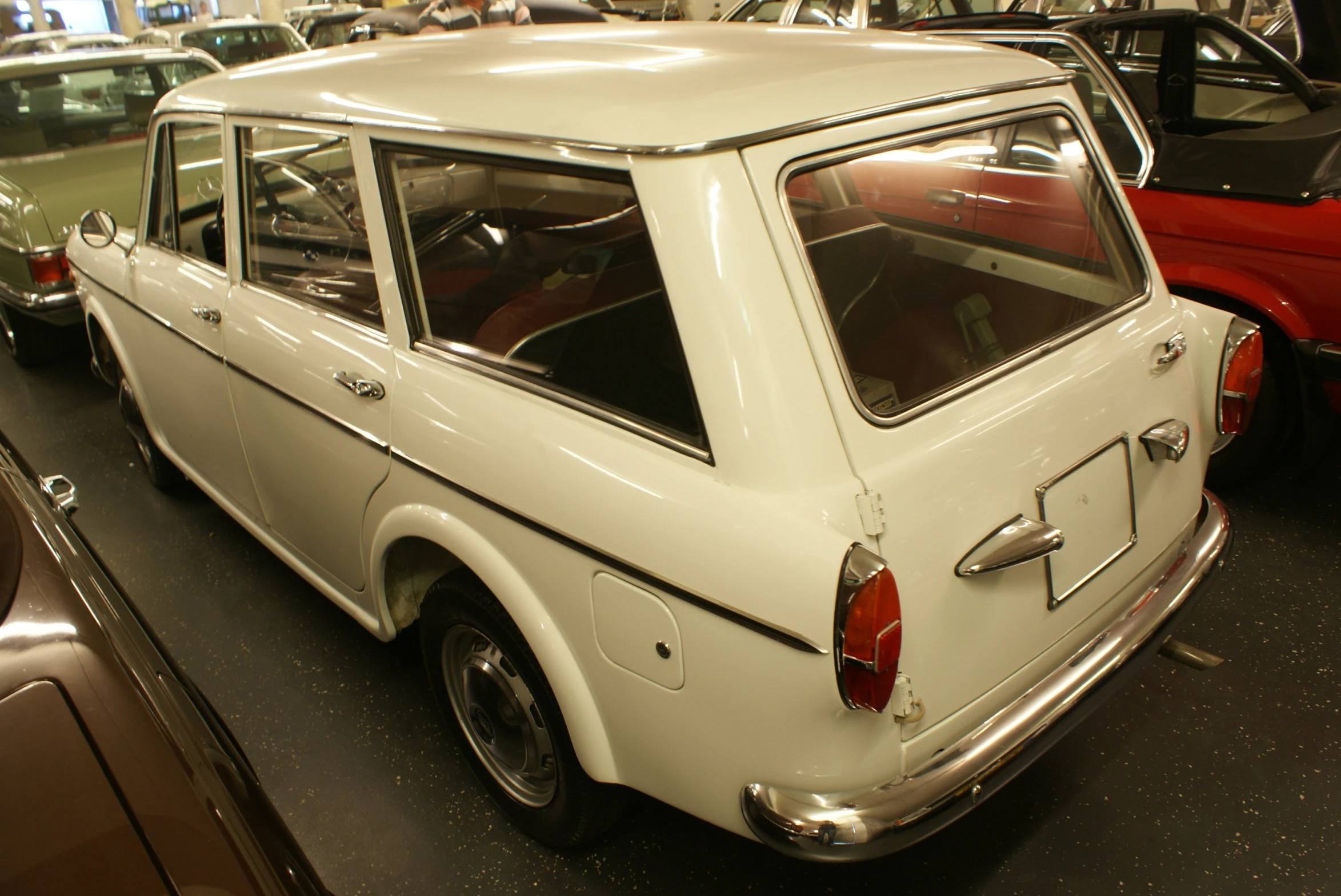 the back end of a white car sitting in a garage