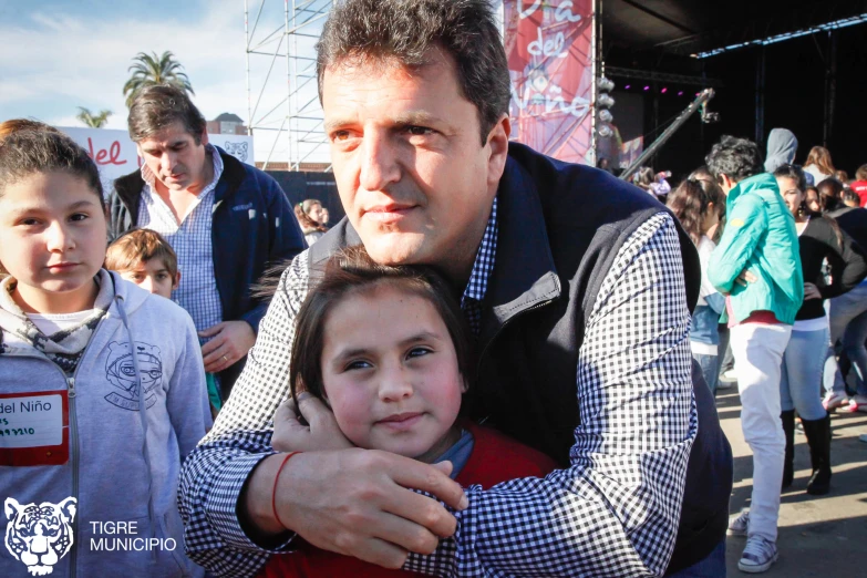 a boy hugs a girl with people surrounding her