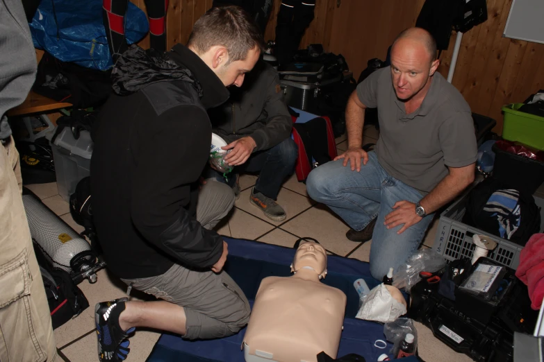 some people gathered around a mannequin dummy