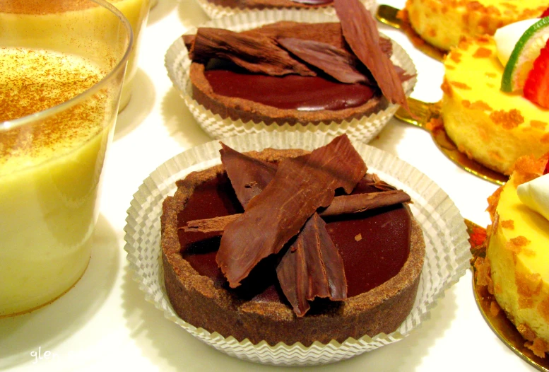 some small pastries on plates next to a cup of drink