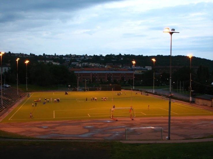 the people are playing on the field at night