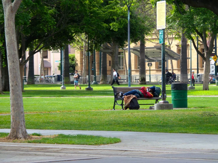 a man laying down on top of a park bench