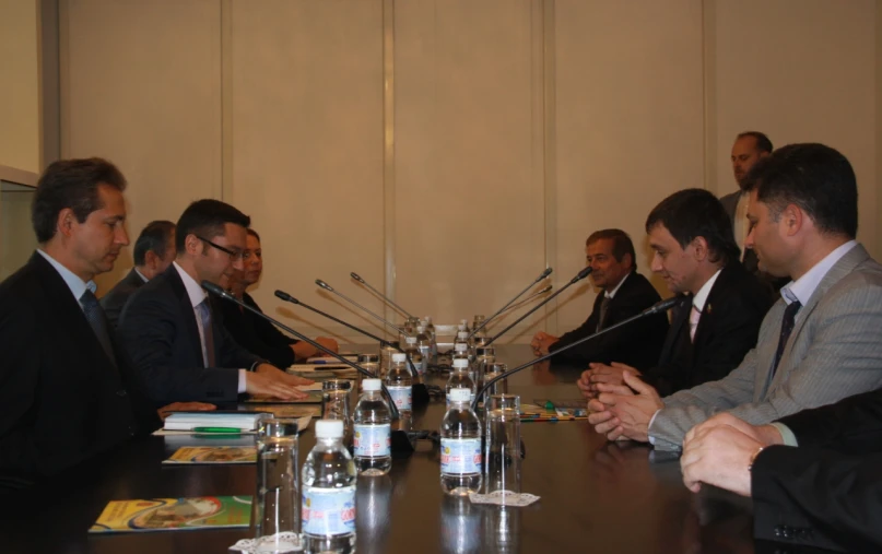 several men wearing suits sitting around a large table