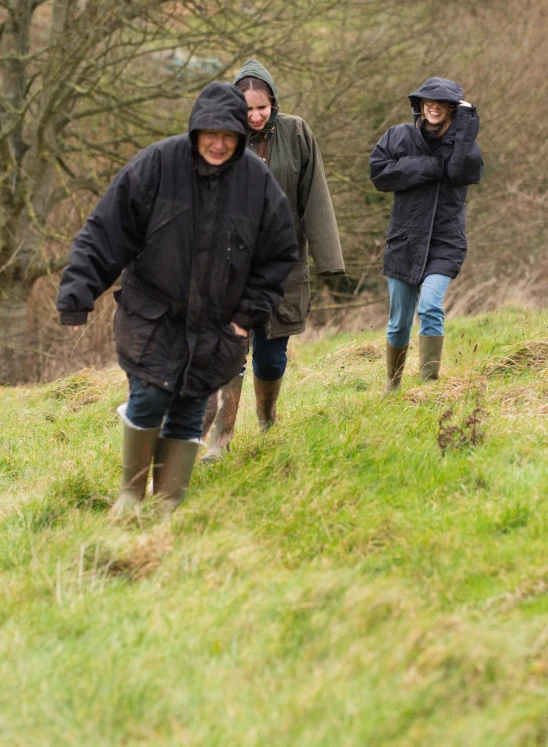 three people are walking in the rain