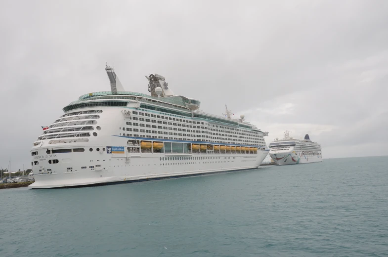 two large cruise ships one is white the other is blue