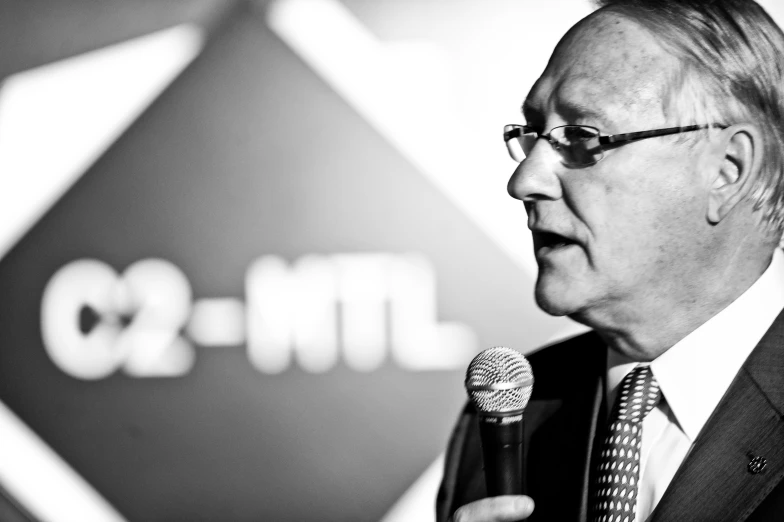 a man speaking at a podium, with a microphone in front of him