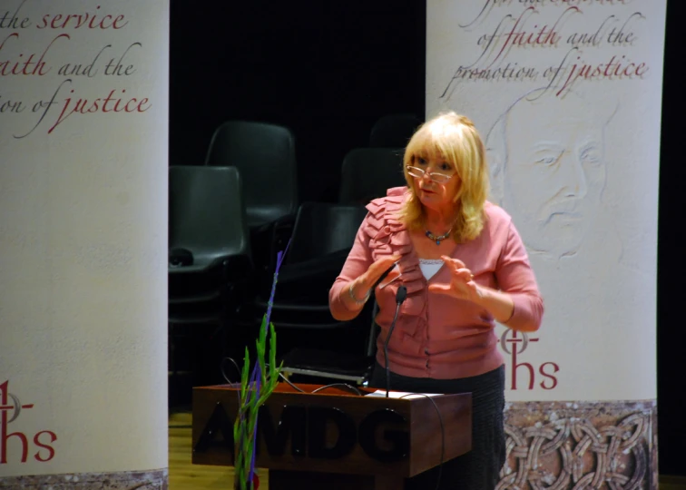 woman standing behind a podium talking at an event