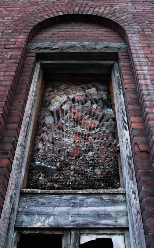 a window in a brick building with mesh over it