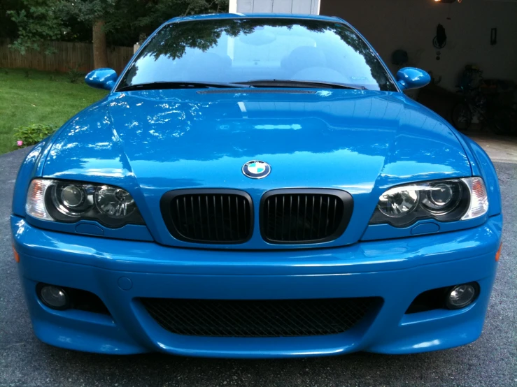 the front end of a blue sports car parked in a driveway