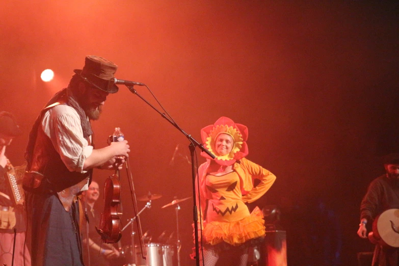 a woman dressed as the wizard next to an adult musician