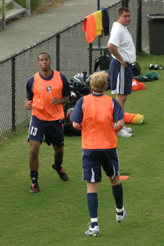 three men on the field playing soccer