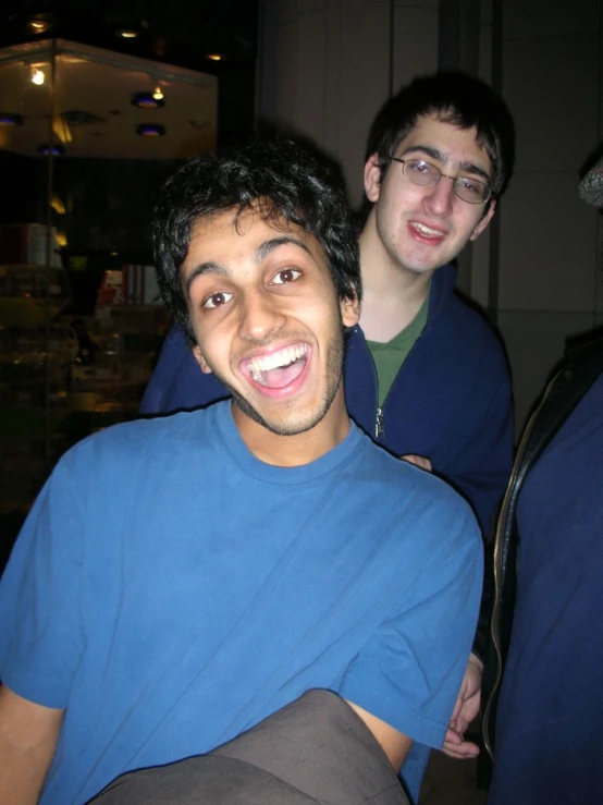 two men are posing for the camera while one man has an umbrella