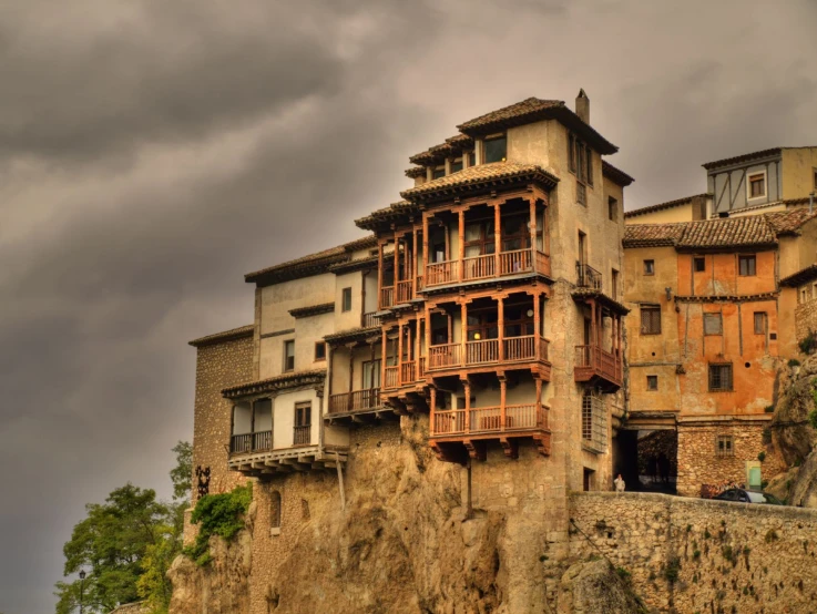 several tall houses built on the edge of a cliff