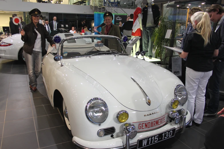 a vintage car sits in the middle of a show room