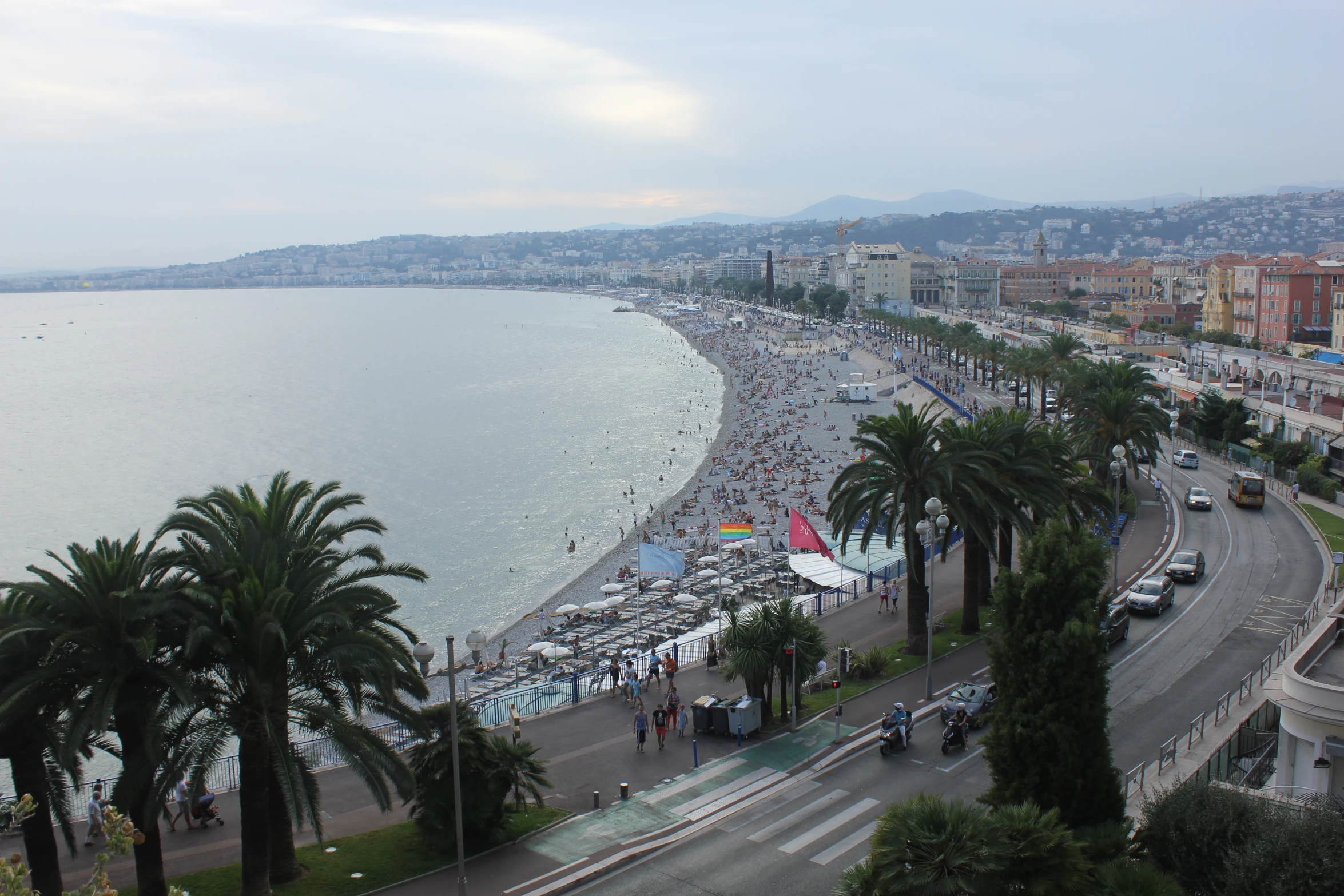 a beach filled with people next to a tall lake