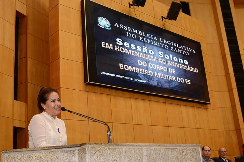 the woman in white is speaking from a podium