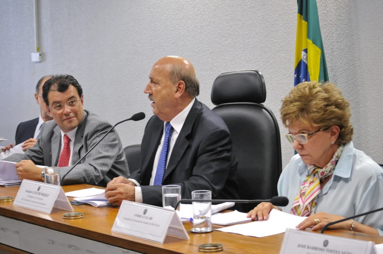 three people sit at a table having a discussion