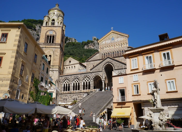 several buildings on a sunny day with tourists milling about