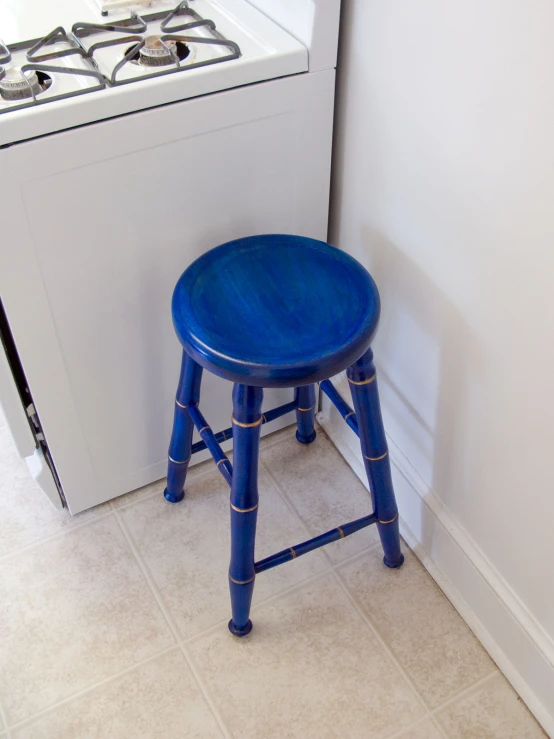 blue stool and stove in small white kitchen