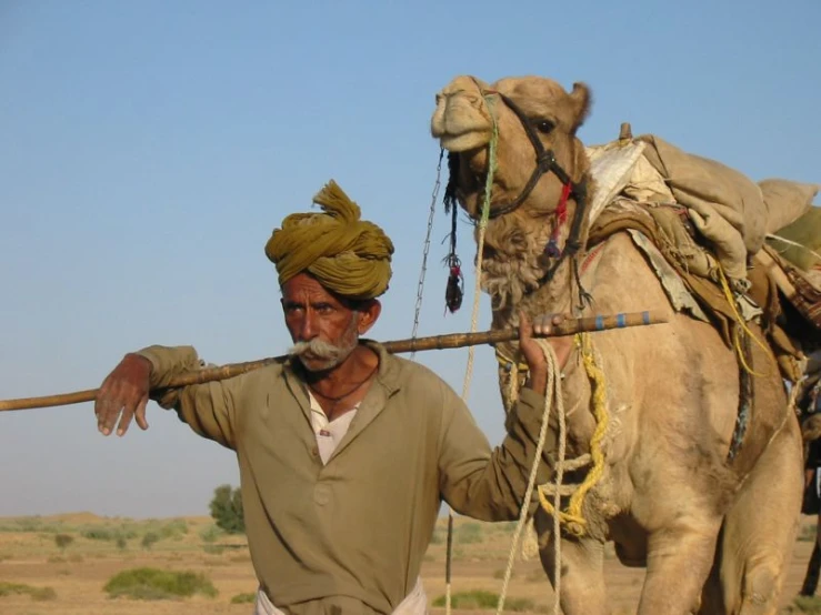 a man riding a camel with a stick in his hand