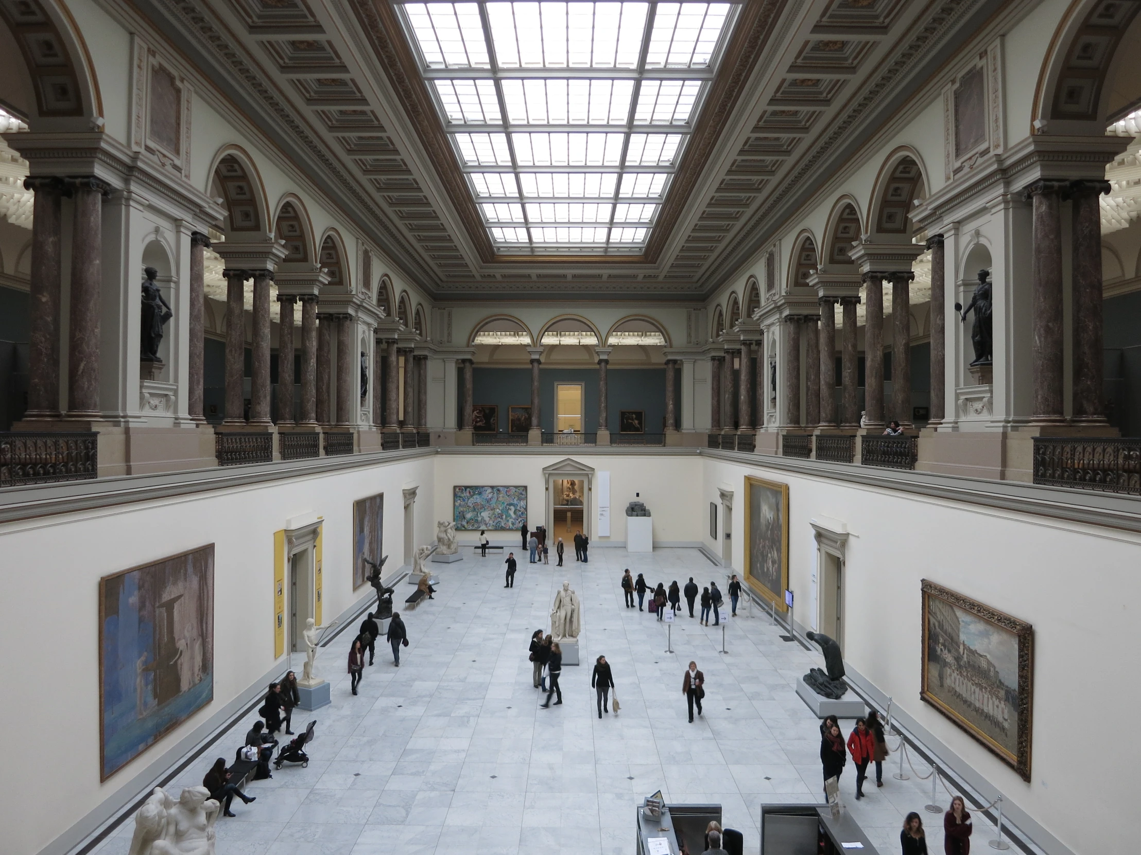 many people walking around the hall inside an office building