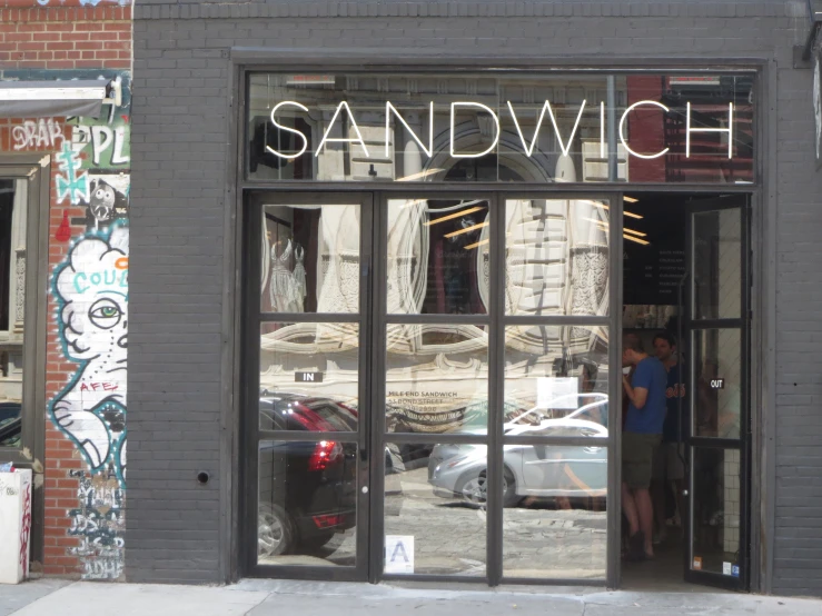 man looking in store window of art piece