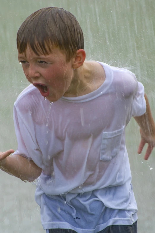 a little boy having fun in the rain