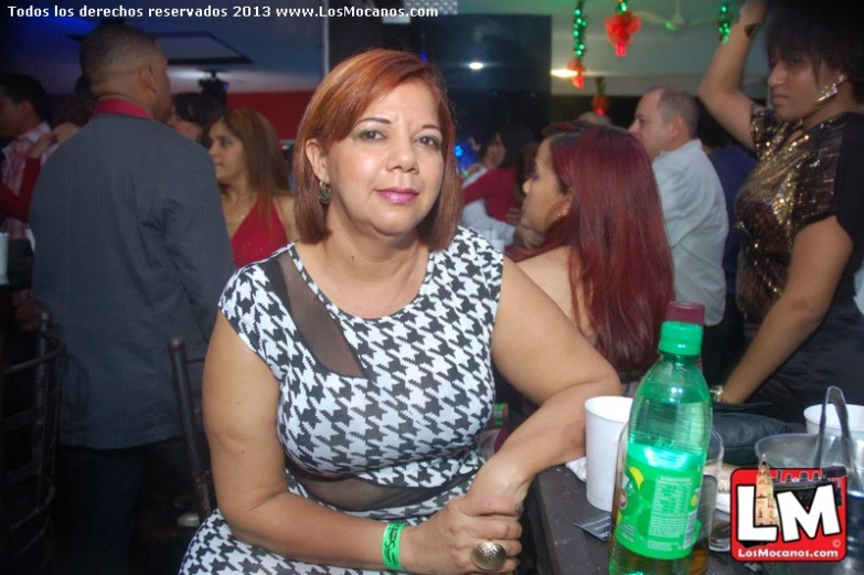 a woman sitting at a bar next to people