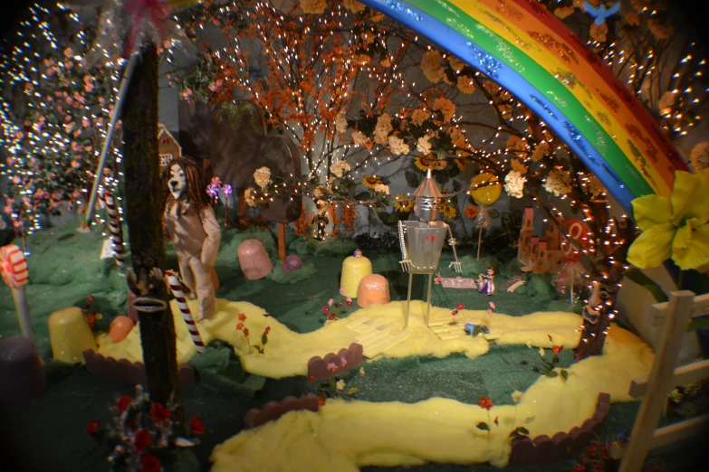 an artificial garden with fake trees, yellow sand and a rainbow