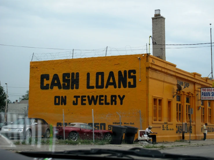 a large yellow building with cars parked in front