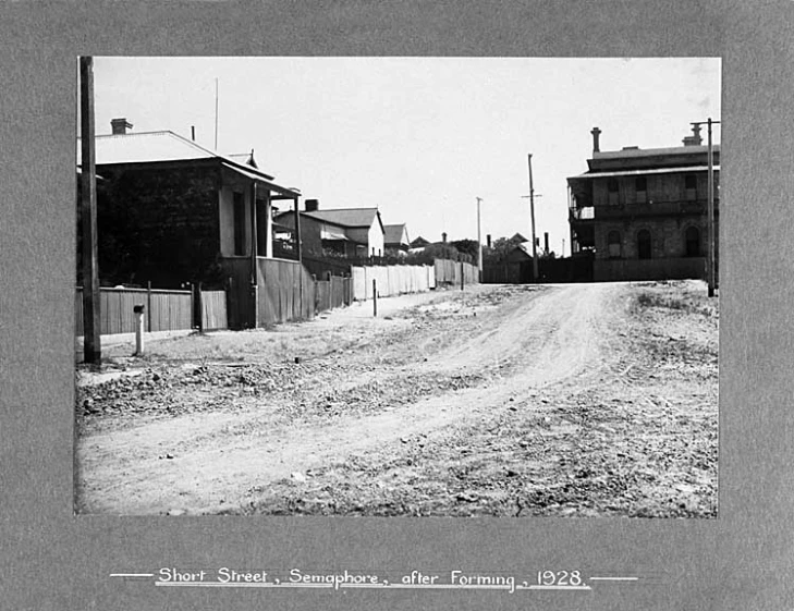 an old po shows a small road with buildings on either side