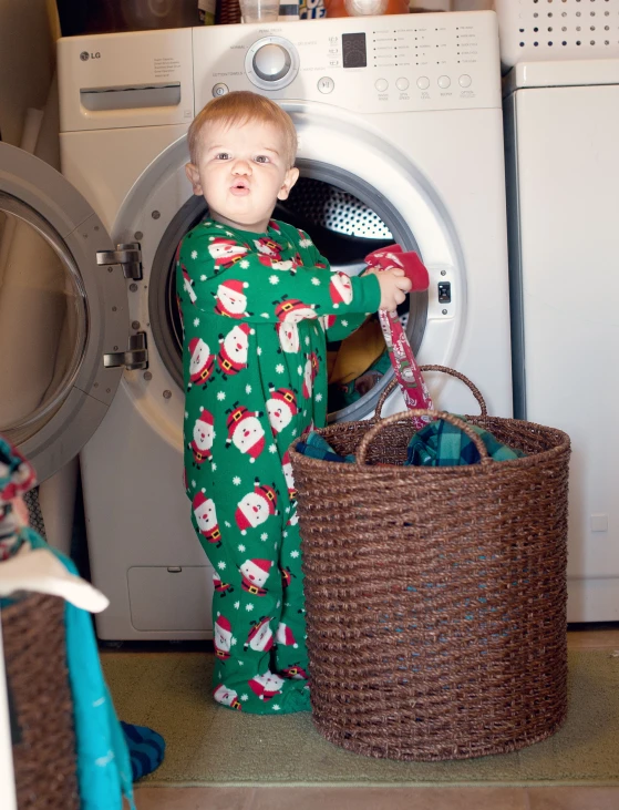 a little boy with a bucket next to his washer