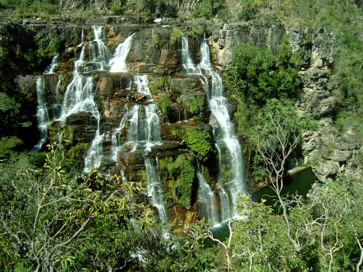 an aerial view of a tall waterfall and trees